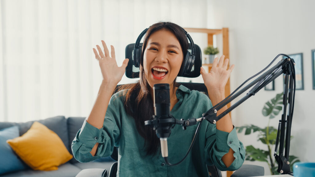 Happy asia girl record a podcast with headphones and microphone
